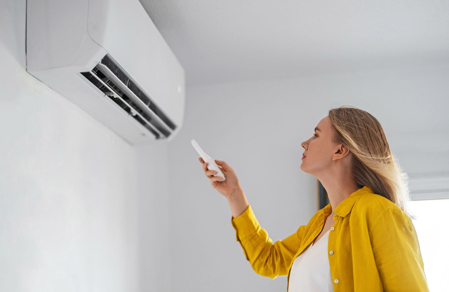Frau schaltet Klimaanlage ein